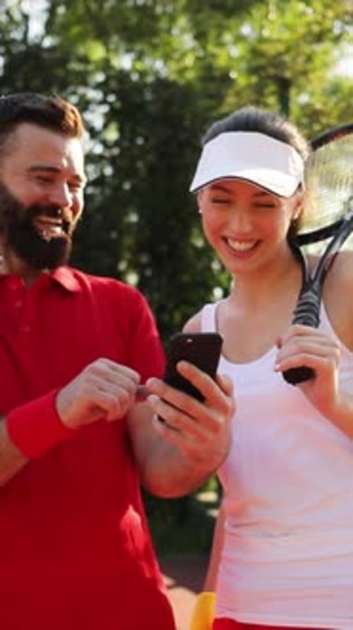 Cheerful Tennis Players Happily Enjoying a Game Break on the Court Under the Sunshine