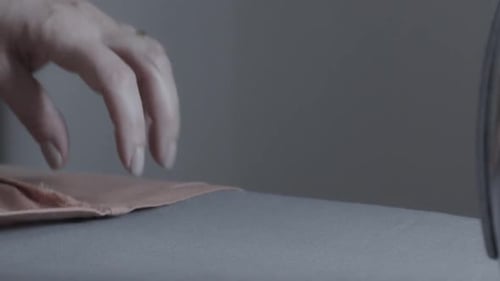 Ironing wrinkled fabric in a textile factory - close up