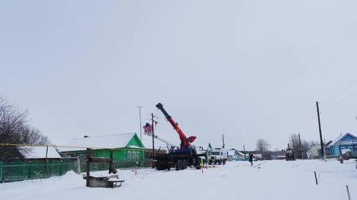 Technicians Repair Power Lines in Village on Winter Day