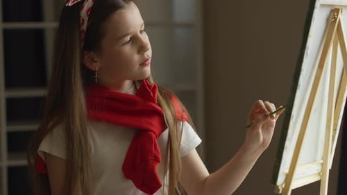 Girl Painting on Canvas with Brush in Studio
