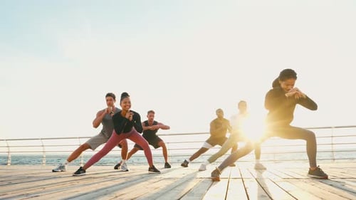 Group Exercises Together on Boardwalk at the Beach