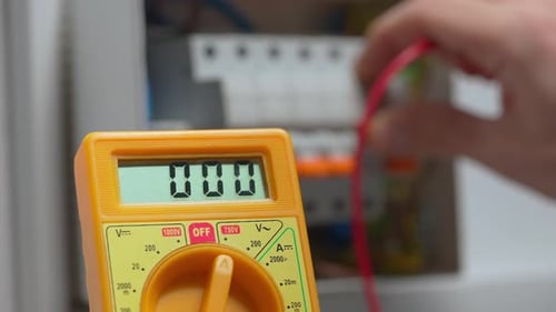 Work Under Voltage Electrician is Checking Serviceability of Equipment Measuring Voltage By Yellow