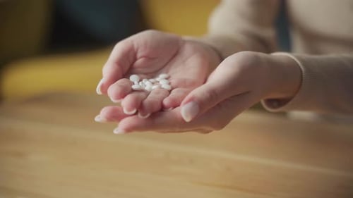 Hands Holding White Medicine Pills Close Up