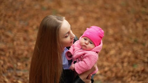 Loving Mother and Infant in Autumn Forest