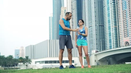 Athletic Man and Woman Resting and Hydrating