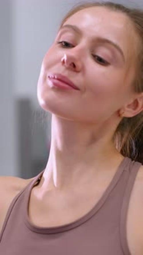Close Up of Woman Practicing Yoga Neck Stretch on Purple Mat