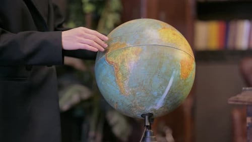 Nahaufnahme einer männlichen Hand, die mit Globe of World arbeitet