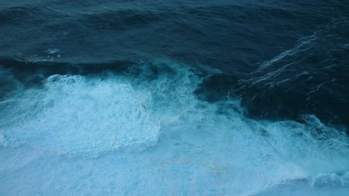 Ocean scene with large, turbulent waves dark blue water contrasts with the white foam power of the w