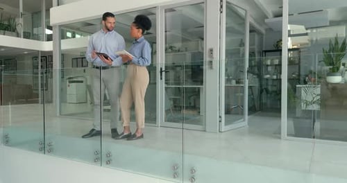 Focused Colleagues Discussing Data on Tablet in Modern Office