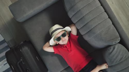 Child with Hat and Sunglasses on Couch