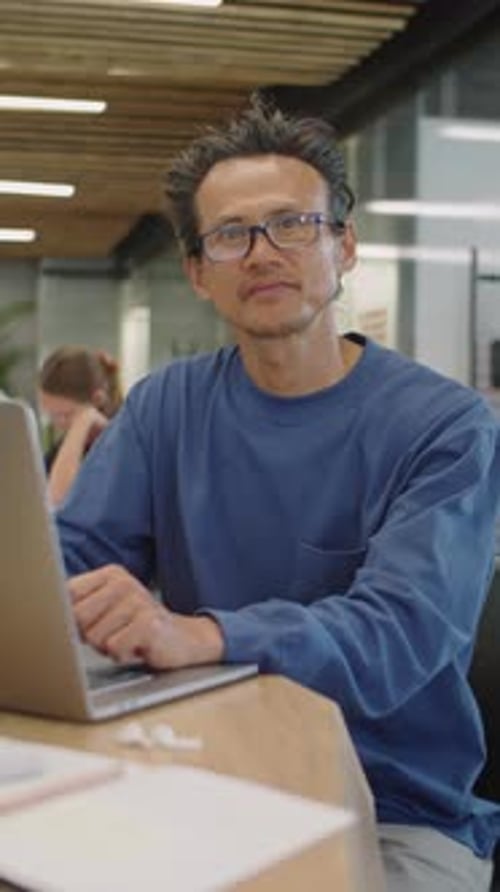 Portrait of Asian Man with Laptop at Office Desk