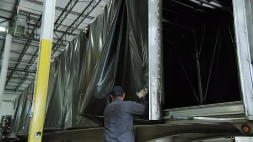 Man Working on a Truck at a Factory