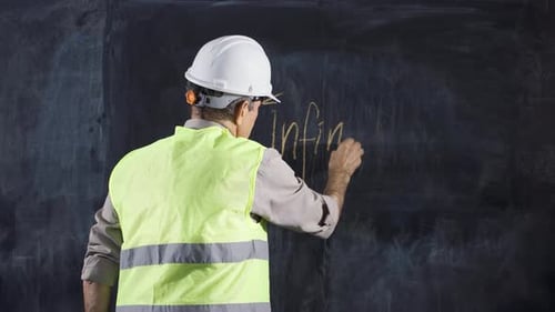 El ingeniero escribe infinitivo en la pizarra.