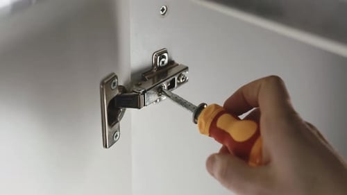 Hand Adjusting Hinge with Screwdriver on Cabinet