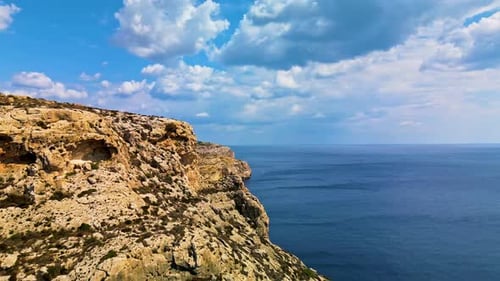 Drone footage of rugged limestone cliffs overlooking the Mediterranean Sea on the coast of Malta.