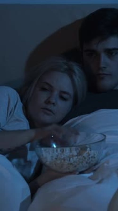 Couple Cuddles in Bed, Watching Scary Movie