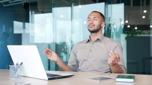 Young Adult Meditating at Desk in Modern Office