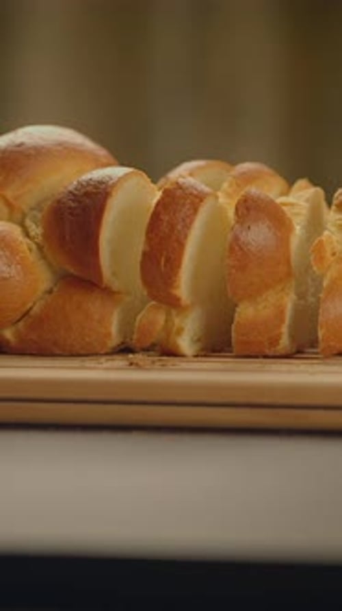 Freshly Sliced Bread Artfully Arranged on a Rustic Wooden Board with a Soft Crust