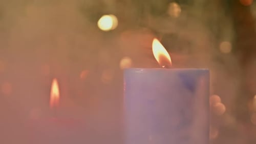 Burning Candles Flames with Blurred Festive Lights