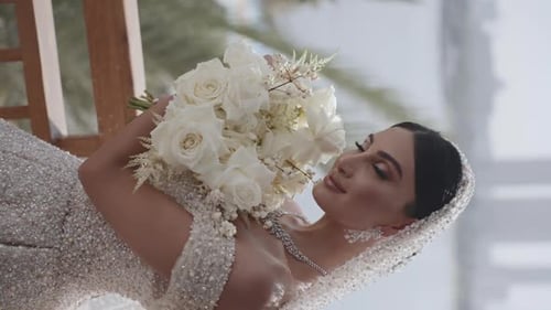 Bride Posing with White Rose Bouquet on Beach