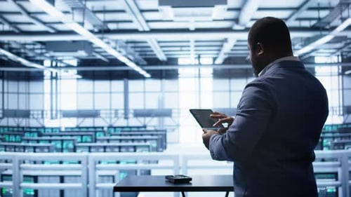 Adult Using Tablet in Futuristic Server Room