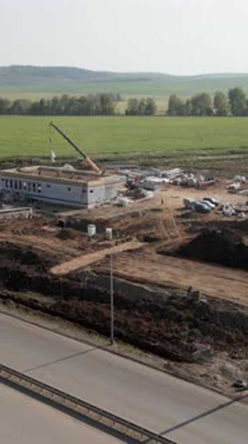 Construction Site Progressing Near Highway with Crane Operating Clip