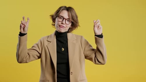 Stylish Young Woman Gesturing Against Yellow Backdrop