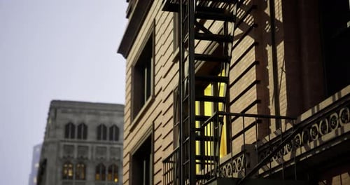 Building Facade with Fire Escape and Yellow Window in Urban Area