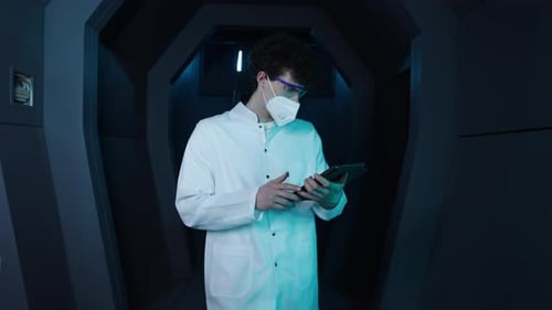 Young Medical Worker Making Notes While Walking Along Corridor