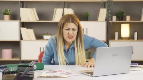 Woman with Stomach Pain at Work on Laptop