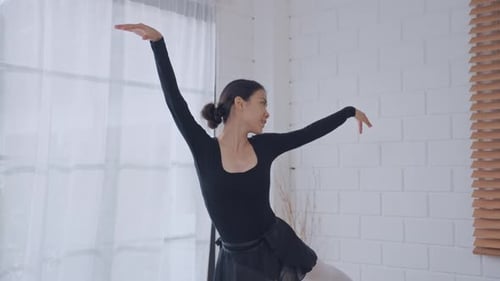 Graceful Woman Practicing Ballet in a Bright Room
