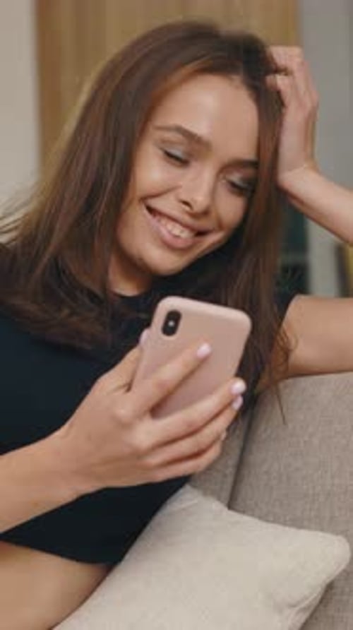 Smiling Woman Using Mobile Phone in Living Room