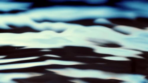 Dunkelblaue Textur der Wasseroberfläche mit sauberen Wellen und Wellenbrechungshintergrund. Zeitlupe