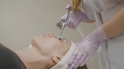 Woman receiving rejuvenating facial treatment in beauty salon