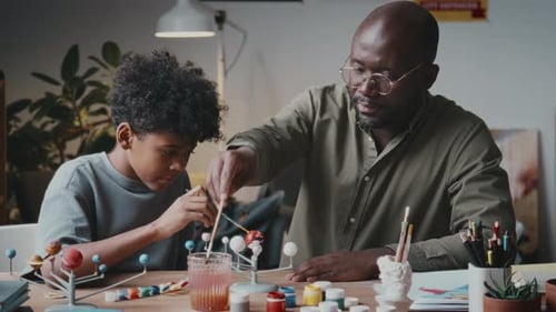 Child and Adult Painting Solar System Model