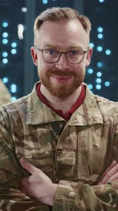 National Army Soldier in Camouflage Arms Crossed Smiling Against Server Room Hightech Data Center