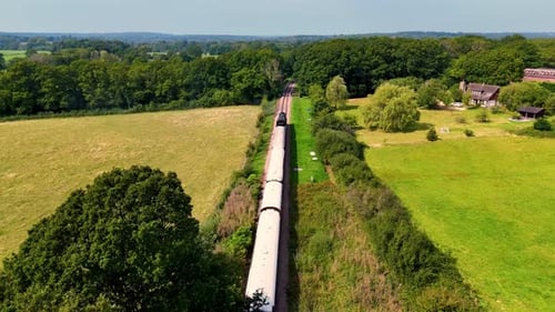 Incredible aerial drone footage follows a vintage steam train from behind as it glides through the p