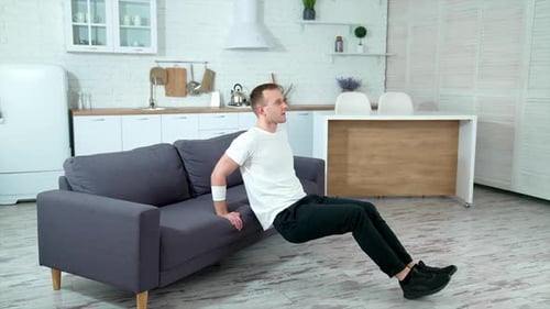 Young Man Doing Tricep Dips on Couch
