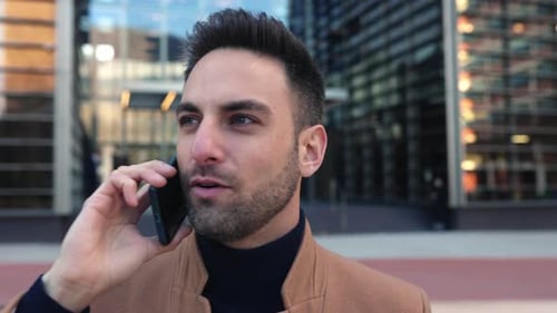Young Businessman Talking on Mobile Phone While Standing Over Business Office
