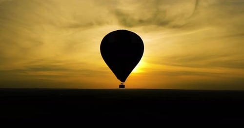 Aerial Drone View of Silhouette Hot Air Balloon Flying Against Sun at Summer Sunrise Balloon Hot Air