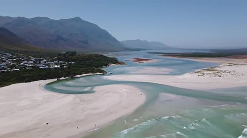 Stunning coastal lagoon estuary system as seen from above with waves entering the open lagoon mouth
