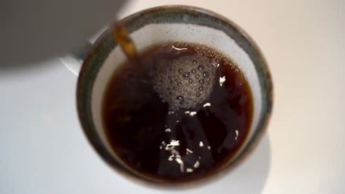 Close up pouring hot filter coffee into cup 4K