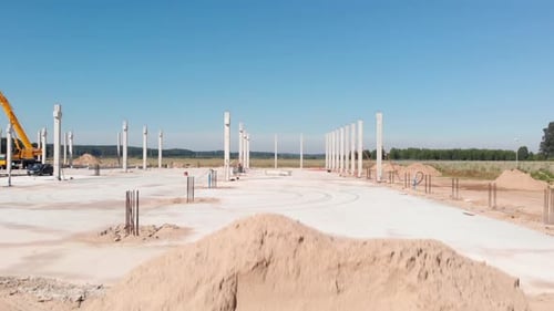 The construction of a hall with concrete columns on foundations is underway