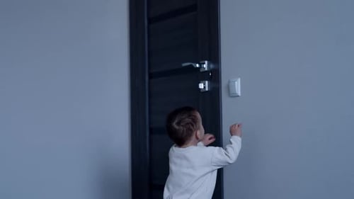 Cute Infant Reaches for Light Switch at Home