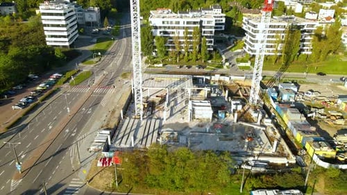 Carretera vacía cerca del sitio de construcción con grúas torre en la ciudad de Gdynia, en Polonia. - aérea, o