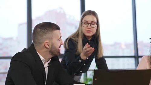 Young female employee persuading colleagues pointing at papers.