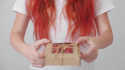 Woman Offers Box of Red Roses as a Gift