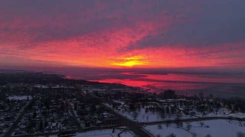 Aerial timelapse of a red sky sunrise over a city waterfront