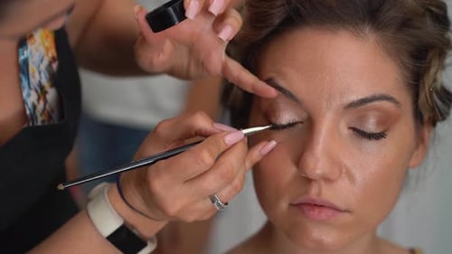 Makeup Artist Applying Eye Shadow to Woman