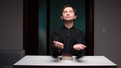 Priest Praying with Rosary and Bible on White Table